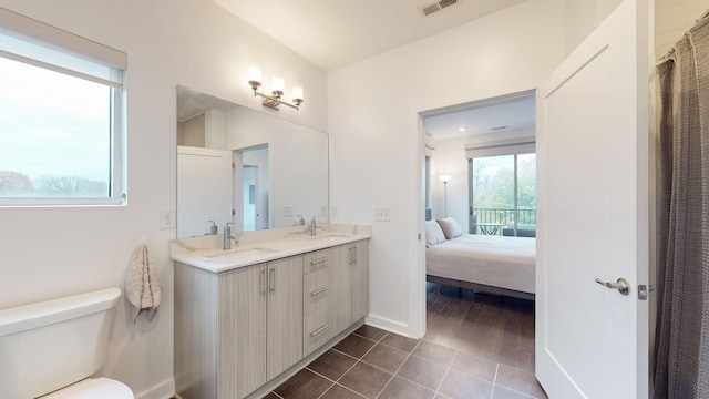 ensuite bathroom with a sink, toilet, connected bathroom, and visible vents