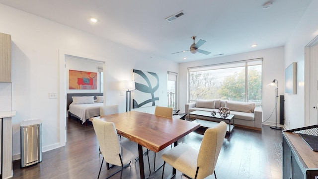 dining room with baseboards, visible vents, a ceiling fan, and dark wood-type flooring