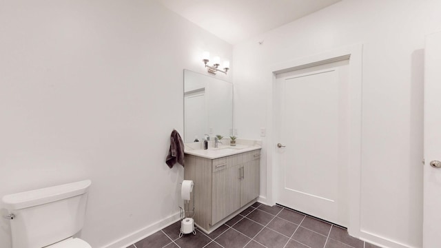bathroom featuring toilet, tile patterned floors, baseboards, and vanity
