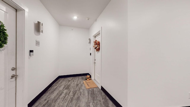 hall featuring baseboards and carpet