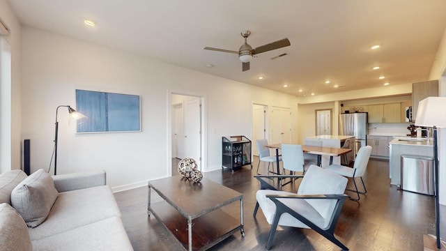 living room featuring dark wood-style flooring, a ceiling fan, baseboards, recessed lighting, and visible vents