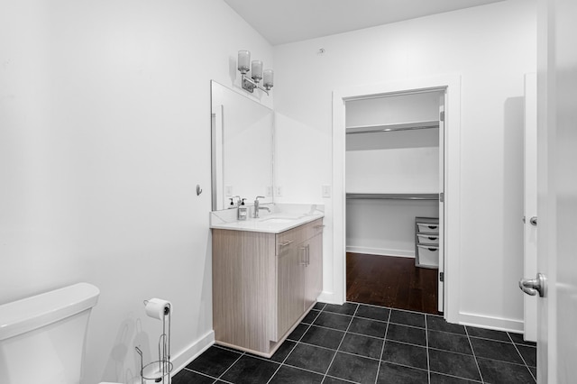 3116 W End Cir Unit 310, Nashville, TN 37203 - bathroom featuring toilet, tile patterned flooring, vanity, baseboards, and a walk in closet