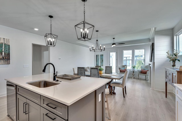 kitchen featuring a sink, light countertops, gray cabinets, and open floor plan