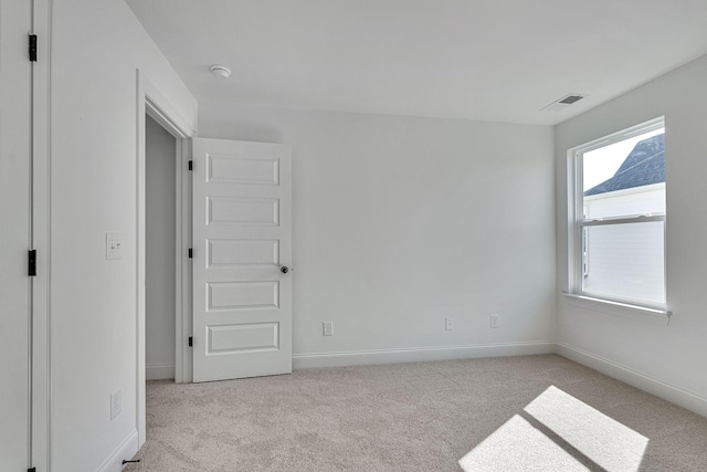 unfurnished bedroom featuring visible vents, baseboards, and light carpet