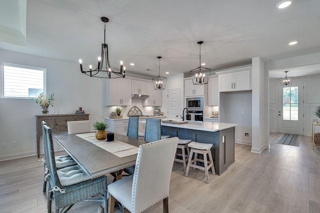 dining space featuring an inviting chandelier, recessed lighting, baseboards, and light wood-type flooring
