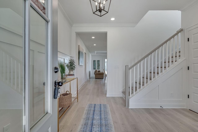 entryway with a chandelier, recessed lighting, light wood-type flooring, ornamental molding, and stairway