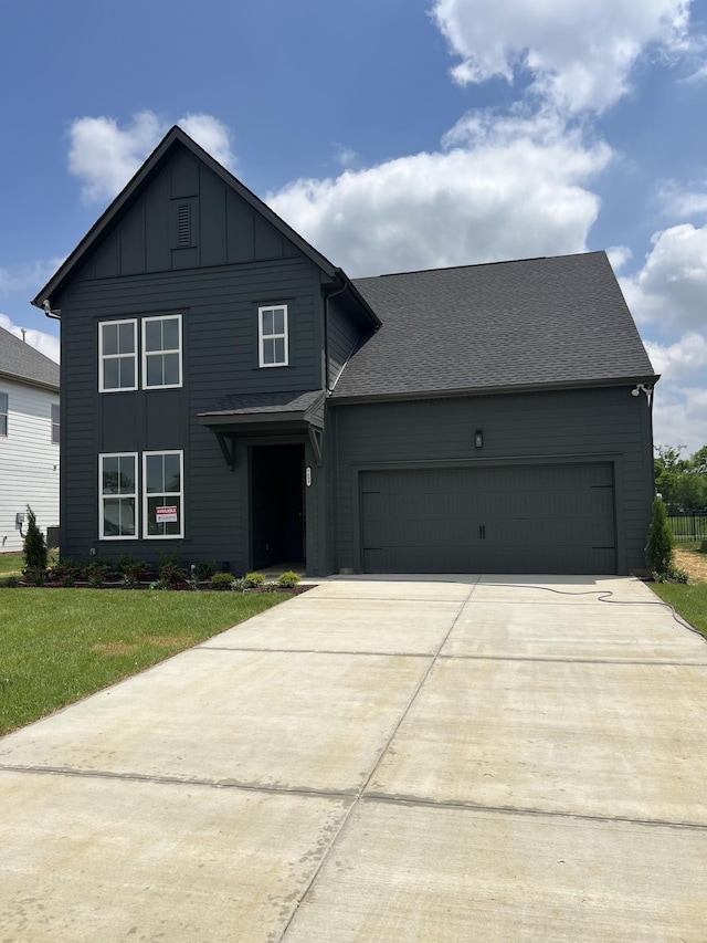 view of front facade featuring a garage, board and batten siding, concrete driveway, and a front yard