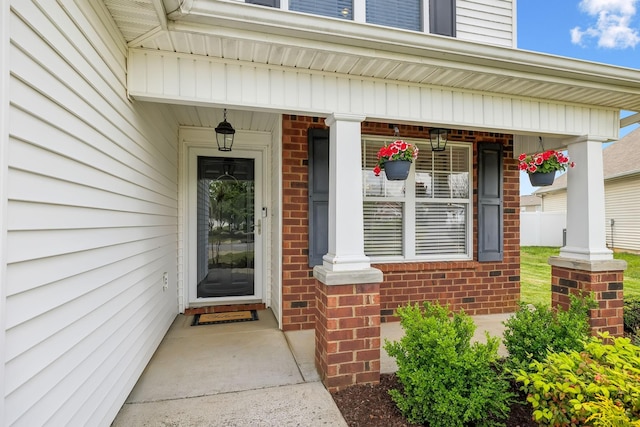 entrance to property featuring brick siding and a porch
