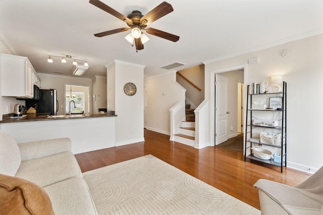 living room featuring visible vents, a ceiling fan, stairs, and crown molding