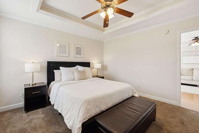 carpeted bedroom featuring crown molding, baseboards, and a tray ceiling