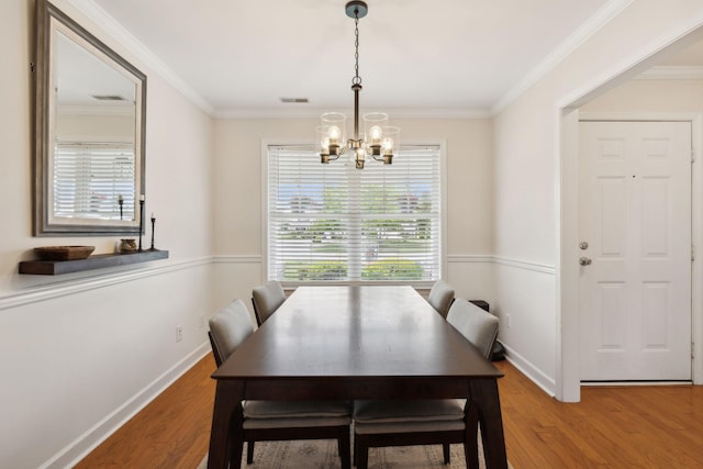 dining area with crown molding, baseboards, a chandelier, and wood finished floors