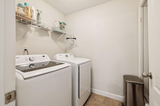 laundry area with baseboards, laundry area, tile patterned floors, and washing machine and clothes dryer
