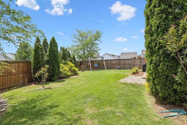 view of yard with a fenced backyard, a playground, and a patio area