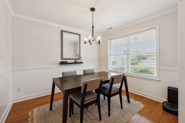 dining room featuring visible vents, crown molding, a chandelier, and hardwood / wood-style floors