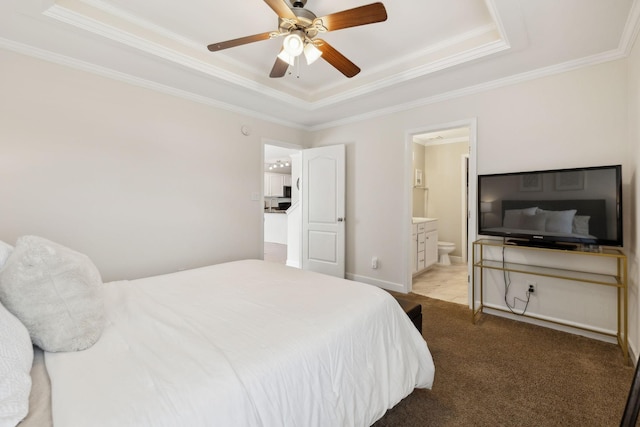 bedroom featuring crown molding, connected bathroom, ceiling fan, carpet floors, and a tray ceiling
