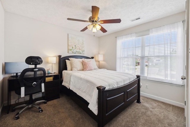 carpeted bedroom featuring a textured ceiling, baseboards, visible vents, and ceiling fan