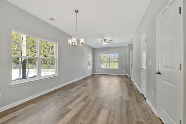interior space featuring baseboards, ceiling fan with notable chandelier, and wood finished floors