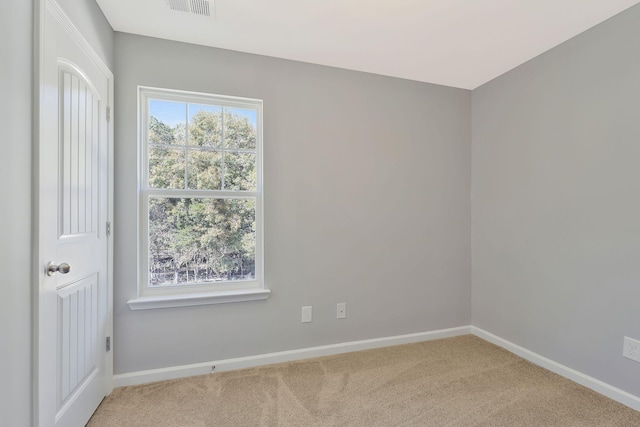 carpeted spare room featuring baseboards and visible vents