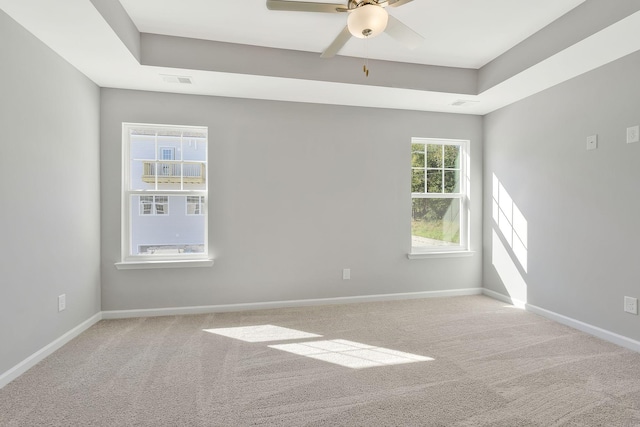 empty room with baseboards, carpet flooring, a ceiling fan, and visible vents