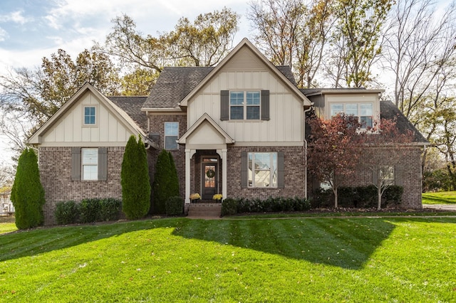 view of front of house with board and batten siding, brick siding, and a front yard
