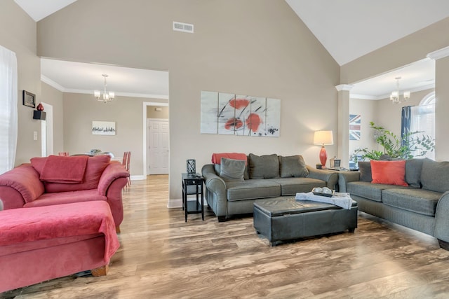 living area with high vaulted ceiling, a chandelier, wood finished floors, and visible vents
