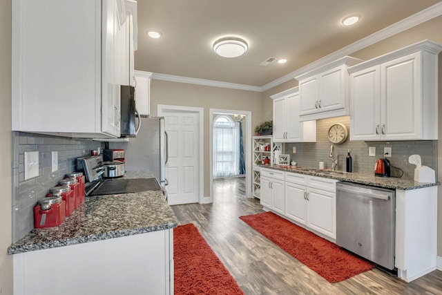 kitchen featuring light wood-style floors, white cabinets, ornamental molding, and stainless steel appliances