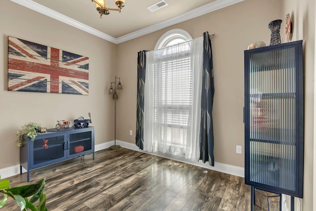 interior space featuring visible vents, baseboards, crown molding, and wood finished floors