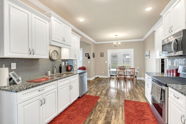 kitchen featuring baseboards, a sink, decorative backsplash, and stainless steel appliances