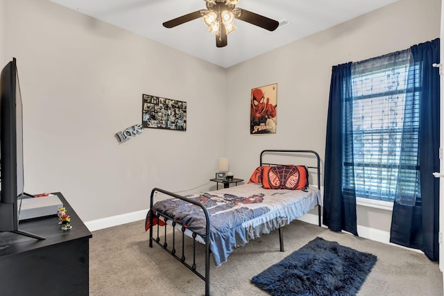 carpeted bedroom featuring baseboards and a ceiling fan