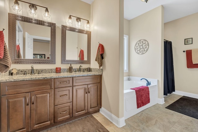 full bathroom featuring double vanity, baseboards, a sink, and a garden tub