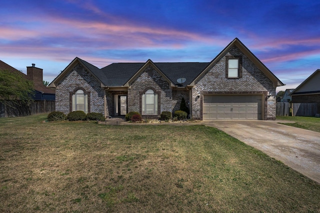 french provincial home featuring fence, concrete driveway, and brick siding