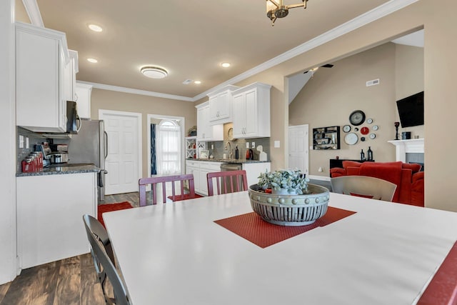 dining area with crown molding, dark wood-style flooring, a fireplace, baseboards, and recessed lighting