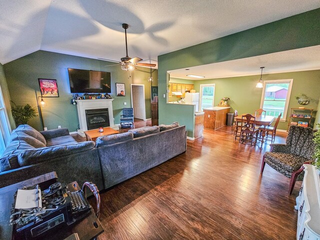 103 Hillcrest Dr, Tullahoma, TN 37388 - living area featuring wood finished floors, a glass covered fireplace, a ceiling fan, baseboards, and lofted ceiling
