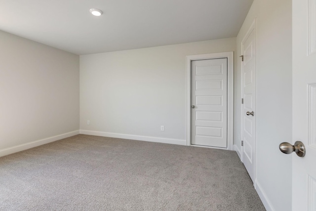 carpeted empty room featuring baseboards