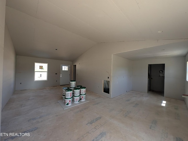unfurnished living room featuring vaulted ceiling