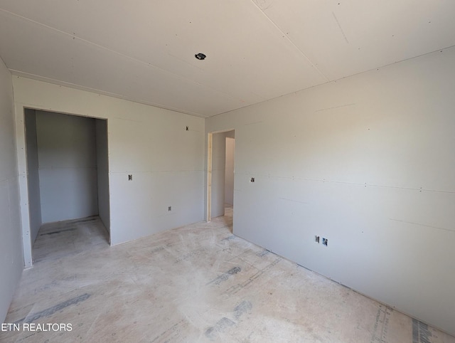 unfurnished bedroom with a closet and concrete floors