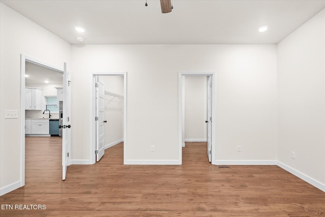 552 Vista View Pkwy, Jamestown, TN 38556 - unfurnished bedroom featuring a sink, a walk in closet, light wood-style flooring, recessed lighting, and baseboards