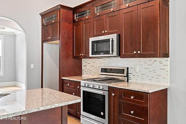 8508 Flowering Peach Ln, Knoxville, TN 37923 - kitchen with appliances with stainless steel finishes, decorative backsplash, ornamental molding, and light stone counters