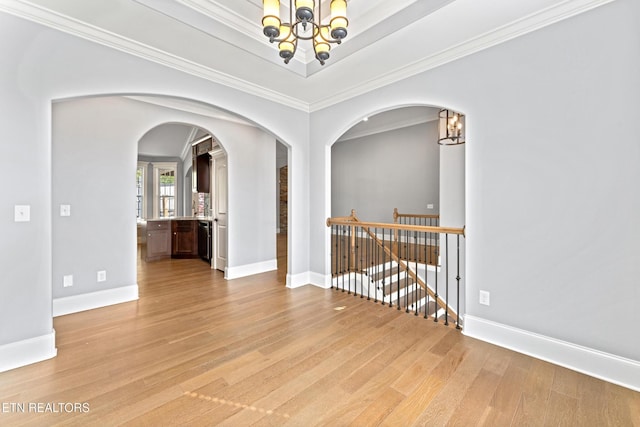 8508 Flowering Peach Ln, Knoxville, TN 37923 - unfurnished room featuring arched walkways, baseboards, light wood-style flooring, and a notable chandelier