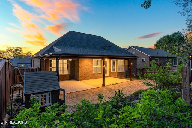 8508 Flowering Peach Ln, Knoxville, TN 37923 - back of house at dusk with brick siding, a fenced backyard, and a patio area