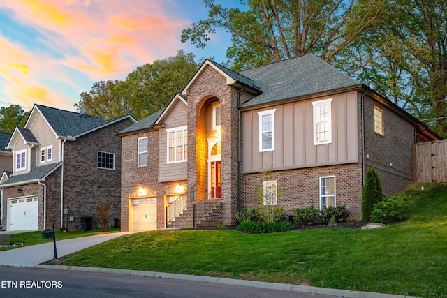 8508 Flowering Peach Ln, Knoxville, TN 37923 - view of front of property with board and batten siding, driveway, a garage, brick siding, and a front lawn