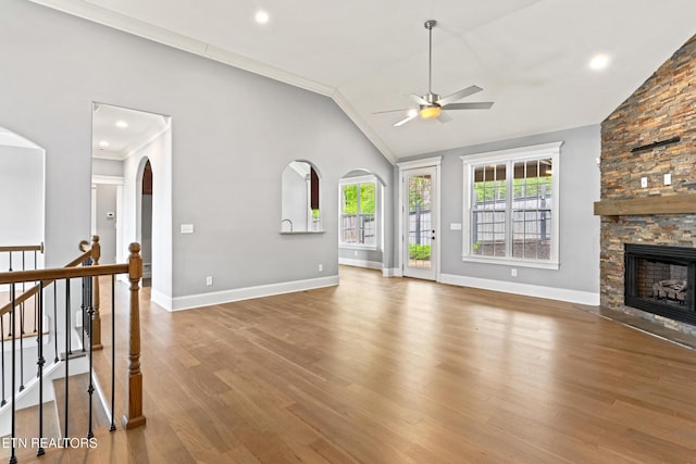 8508 Flowering Peach Ln, Knoxville, TN 37923 - unfurnished living room featuring lofted ceiling, wood finished floors, baseboards, arched walkways, and a ceiling fan
