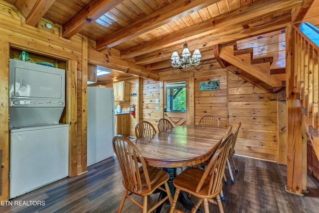 dining room featuring stacked washing maching and dryer, wooden ceiling, wooden walls, an inviting chandelier, and dark wood-type flooring