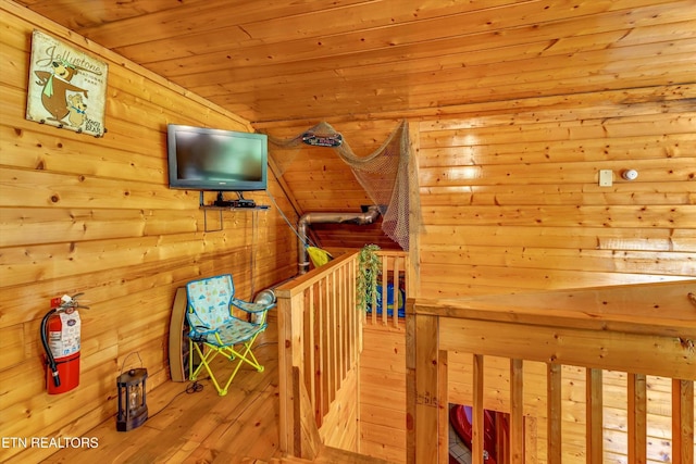 interior space featuring wooden walls, wood ceiling, and hardwood / wood-style floors