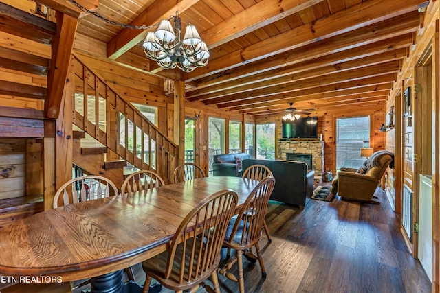 dining room featuring wood walls, plenty of natural light, beam ceiling, and a fireplace