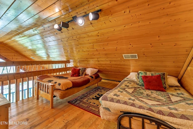 bedroom featuring wood walls, visible vents, wooden ceiling, and hardwood / wood-style floors