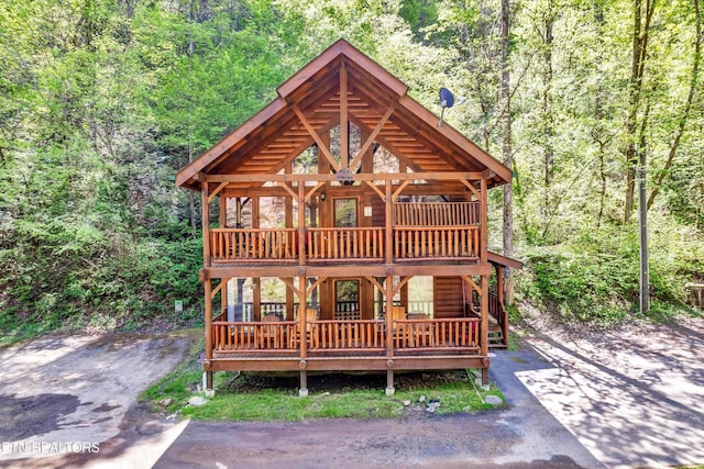 log home with a forest view and a wooden deck