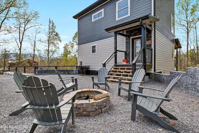 rear view of property with an outdoor fire pit