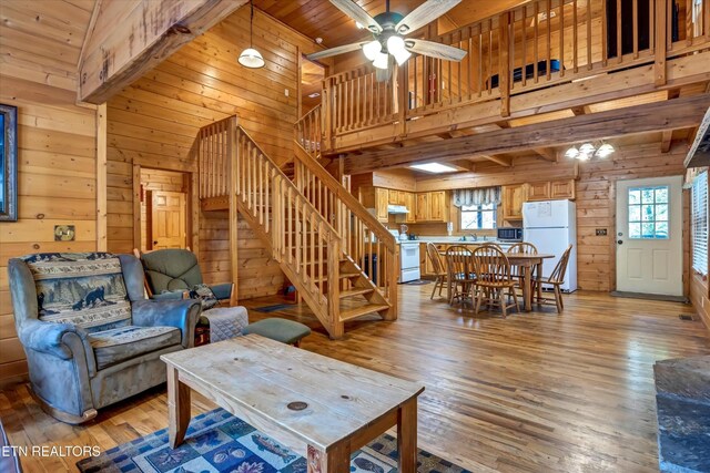 415 Silver Maple Ln, Gatlinburg, TN 37738 - living area featuring wood walls, light wood-style flooring, a ceiling fan, a towering ceiling, and stairway