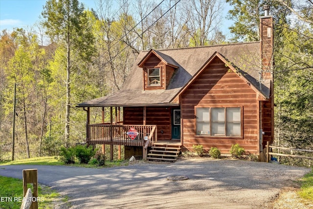 415 Silver Maple Ln, Gatlinburg, TN 37738 - view of front facade with covered porch, driveway, a shingled roof, and a chimney